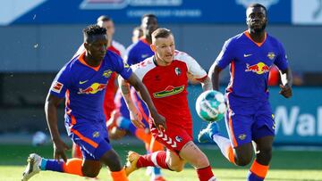 Leipzig's Malian midfielder Amadou Haidara (L) and Freiburg's French midfielder Jonathan Schmid (C) vie for the ball during the German first division Bundesliga football match between SC Freiburg and RB Leipzig in Freiburg, southwestern Germany,