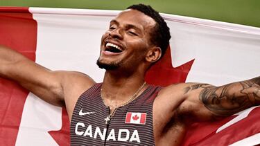 Canada's Andre De Grasse celebrates with his national flag after winning gold after the men's 200m final during the Tokyo 2020 Olympic Games at the Olympic Stadium in Tokyo on August 4, 2021. (Photo by Jeff PACHOUD / AFP)