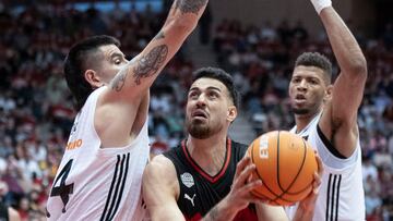 GIRONA, 27/04/2025.- Juan Fernández (c), del Basquet Girona, entra a canasta ante los jugadores del Real Madrid Gabriel Dech y Edy Tavares (d), durante el partido de Liga Endesa que ambos equipos disputan este domingo en el Pabellón de Fontajau de Girona. EFE/David Borrat