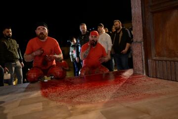 Christian Sgamba, izquierda, se golpea con un trozo de corcho con fragmentos de vidrio durante el antiguo rito pascual de 'Los Battenti' (Los flagelantes) en la iglesia de San José en Verbicaro, en el extremo sur de Italia.