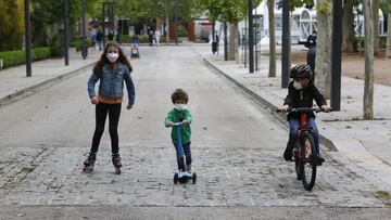 Tres niños practican deporte al aire libre protegidos con mascarillas