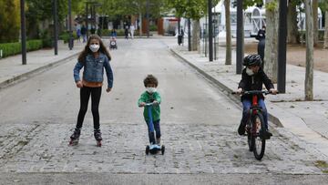 Tres ni&ntilde;os practican deporte al aire libre protegidos con mascarillas