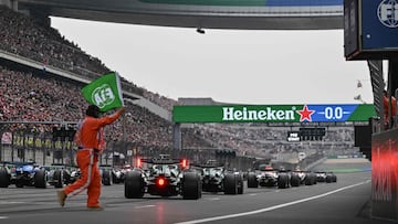 Un comisario de pista ondea la bandera verde antes de la salida del GP de China de F1 2026.
