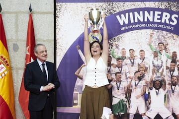 La presidenta de la Comunidad de Madrid, Isabel Díaz Ayuso (d), acompañada por el presidente del Real Madrid, Florentino Pérez, levanta una réplica de la Copa de la Liga de Campeones.