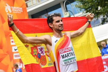 Álvaro Martín posa con la bandera española tras llegar a la línea de meta en primer lugar.