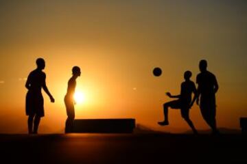 Cuatro niños juegan al fútbol en los tejados de una favela de Rio de Janeiro en Brasil