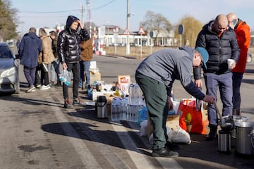 Volunteers hand out tea, water and food to people crossing the border from Ukraine into the Romanian town of Siret.