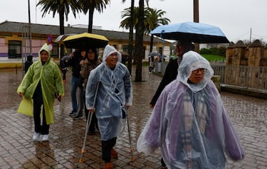 Turistas caminan en medio de las inundaciones del río Guadalquivir durante las fuertes lluvias mientras la tormenta Marta azota partes de España.