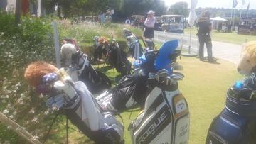 Bolsas de palos de golf en el 'bag drop' de las jugadoras, junto a los buggies y personal de seguridad en el Aramco Team Series de Sotogrande.