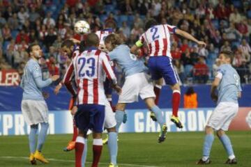 El defensa uruguayo del Atlético de Madrid, Diego Godín (2d), cabecea un balón ante la defensa del Malmoe, consiguiendo el cuarto gol del equipo colchonero