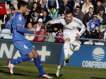 El delantero del Real Madrid Jesé Rodríguez (d) con el balón dispara a puerta para marcar ante el defensa argentino del Getafe Lisandro López, durante el partido de la vigésimo cuarta jornada de liga de Primera División.