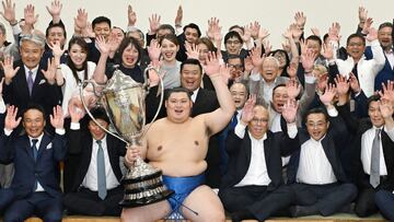 Sumo wrestler Onosato (C) celebrates with the trophy after his winning of the Grand Sumo Tournament in Tokyo's Kokugikan Arena on May 26, 2024. (Photo by JAPAN POOL / JIJI PRESS / AFP) / Japan OUT