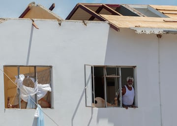 Un hombre mira por la ventana de su casa, que fue destruida por el huracán Beryl en Clifton, Union Island, San Vicente y las Granadinas.