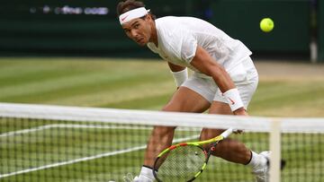 Rafa Nadal devuelve una bola ante Novak Djokovic en las semifinales de Wimbledon 2018.