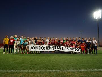 Las jugadoras y demás personal técnico, del Atlético de Madrid y del Milan, sostienen una pancarta de apoyo a Jenni Hermoso.