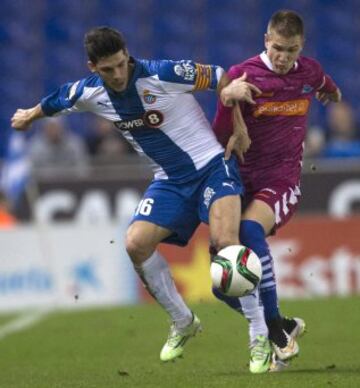 El defensa del RCD Espanyol Javi López (i) pelea un balón con Raúl Gracía, del Alavés, durante el partido de vuelta de dieciseisavos de final de la Copa del Rey de fútbol que se disputa esta noche en el estadio Cornellá-El Prat, en Barcelona. 