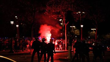 Paris Saint-Germain supporters leave as French CRS riot police intervene during celebrations of PSG's 3-0 win over RB Leipzig at the Champs-Elysees Avenue in Paris on late August 18, 2020 following the UEFA Champions League semi-final football match