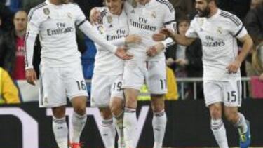 Luka Modric, rodeado por sus compañeros.