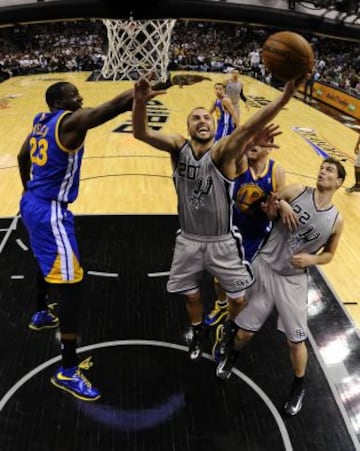 Spurs 109 - Warriors 91 (3-2). El jugador de los Spurs de San Antonio Manu Ginobili (c) entra a canasta a pesar de la defensa de Draymond Green (izq), de los Warriors de Golden State.