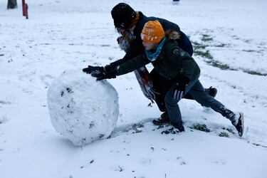 La gente hace muñecos de nieve tras una nevada.

