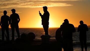 People are silhouetted at sunset as they visit the Malecon, one day ahead of a total solar eclipse in Mazatlan, Mexico April 7, 2024. REUTERS/Henry Romero