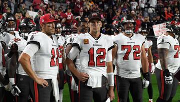 GLENDALE, ARIZONA - DECEMBER 25: Blaine Gabbert #11, Tom Brady #12 and Josh Wells #72 of the Tampa Bay Buccaneers stand on the sidelines prior to the start of the game against the Arizona Cardinals at State Farm Stadium on December 25, 2022 in Glendale, Arizona. Norm Hall/Getty Images/AFP (Photo by Norm Hall / GETTY IMAGES NORTH AMERICA / Getty Images via AFP)