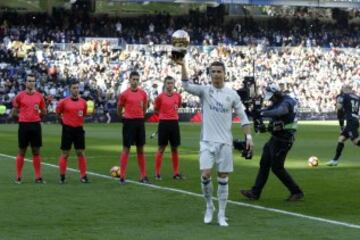 Cristiano ofrece a la grada del Santiago Bernabéu su cuarto galardón como mejor futbolista del mundo.