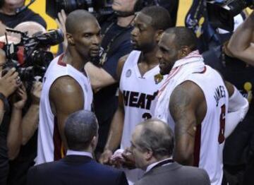 El jugador de los Heat de Miami LeBron James (centro) y sus compañeros Dwyane Wade (dcha) y Chris Bosh (izda) celebran tras ganar el sexto partido de las finales contra los Spurs en el American Airlines Arena de Miami en Florida