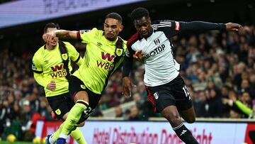 Burnley's Brazilian defender #22 Vitinho (L) vies with Fulham's Senegalese defender #12 Fode Ballo-Toure during the English Premier League football match between Fulham and Burnley at Craven Cottage in London on December 23, 2023. (Photo by HENRY NICHOLLS / AFP) / RESTRICTED TO EDITORIAL USE. No use with unauthorized audio, video, data, fixture lists, club/league logos or 'live' services. Online in-match use limited to 120 images. An additional 40 images may be used in extra time. No video emulation. Social media in-match use limited to 120 images. An additional 40 images may be used in extra time. No use in betting publications, games or single club/league/player publications. / 