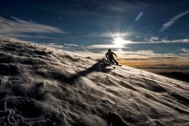 El macizo de Bauges es una cadena montañosa en el este de Francia que forma lo que se conoce como los Prealpes franceses, un lugar ideal para la práctica de deportes de invierno. Allí, un aficionado al snowboard desciende en solitario y al atardecer por una empinada pista en Viuz-la-Chiesaz, cerca de la estación de esquí de Semnoz.