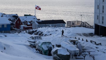 A Greenland flag flies as a man walks on the day of the meeting between top U.S. officials and the foreign ministers of Denmark and Greenland, in Nuuk, Greenland, January 14, 2026. REUTERS/Marko Djurica