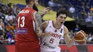 Turkey&#039;s Cedi Osman (R) is blocked by Serbia&#039;s Miroslav Raduljica during the EuroBasket group B qualification basketball match between Turkey and Serbia in Berlin on September 9, 2015. AFP PHOTO / TOBIAS SCHWARZ