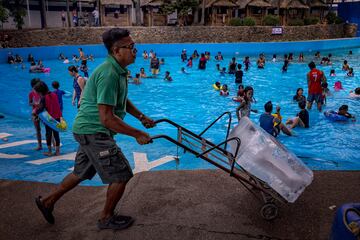 Los trabajadores se preparan para arrojar bloques de hielo a una piscina en medio de un calor extremo en el Hidden Sanctuary Resort el 4 de mayo en Marilao, provincia de Bulacan, Filipinas. Las temperaturas abrasadoras se apoderaron de las principales ciudades de Asia, estableciendo nuevos récords. En Filipinas, las temperaturas se llegaron hasta los 53 grados. 