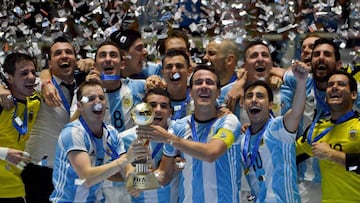 Argentina's team players celebrate with the trophy after defeating Russia to win the Colombia 2016 FIFA Futsal World Cup championship at the Coliseo El Pueblo stadium, in Cali, Colombia on October 1, 2016. / AFP PHOTO / LUIS ROBAYO