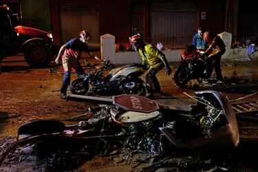Un equipo de rescate retira unas motocicletas de la calle tras las lluvias torrenciales que provocaron inundaciones en Alfafar, Valencia.