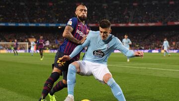 El lateral eslovaco Robert Mazan, del Celta, defiende el bal&oacute;n ante el centrocampista chileno Arturo Vidal, del Barcelona, en el Camp Nou.