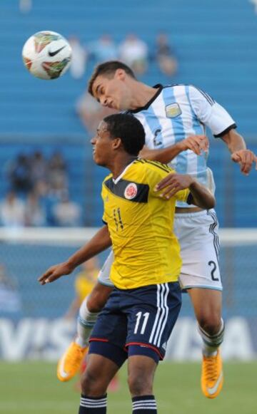 Jeison Lucumi  (izquierda) lucha un balón aéreo con Emanuel Mammana.