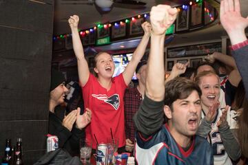 Los aficionados de los Patriots se reunieron en bares para ver el partido mientras comían alitas y bebían cervezas. En la imagen seguidores celebrando la intercepeción que dio medio título a los Patriots.