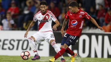 Juan Fernando Quintero disputa una pelota frente a Milton Casco.