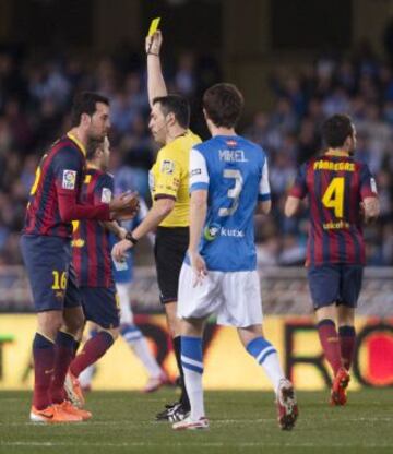 El árbitro Fernando Teixeira Vitienes amonesta con cartulina amarilla a Sergio Busquets.