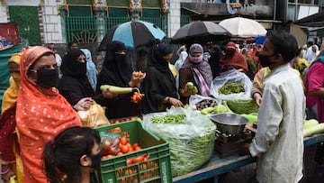 People buy vegetables at a market during a government-imposed nationwide lockdown as a preventive measure against the spread of the COVID-19 coronavirus in Ahmedabad on April 16, 2020. (Photo by Sam PANTHAKY / AFP)