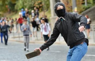 Un aficionado del Zorya Lugansk con un ladrillo en la mano para lanzarlo al cordón policial. 