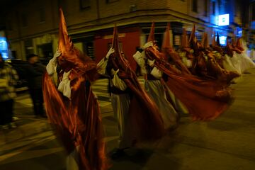 Penitentes encapuchados se protegen del fuerte viento en la procesión del Miércoles Santo en Calahorra, La Rioja, España.