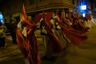 Penitentes encapuchados se protegen del fuerte viento en la procesión del Miércoles Santo en Calahorra, La Rioja, España. 