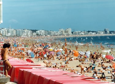 Playa llena en un día de verano de 1981 con el mar y los hoteles a la vista en Gran Canaria 