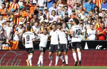 El delantero argentino del Valencia Pablo Piatti acelebra con varios compañeros el gol marcado al Espanyol, durante el partido de la tercera jornada de Liga de Primera División, disputado esta tarde en el estadio de Mestalla.