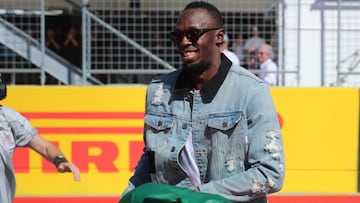 Usain Bolt ondea la bandera verde antes de la vuelta de formaci&oacute;n en el Gran Premio de Estados Unidos de F&oacute;rmula 1 en el Circuito de las Am&eacute;ricas.