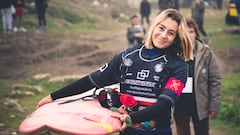 Laura Coviella con una rosa y una tabla de surf yendo al agua en el campeonato de surf de olas grandes La Vaca Gigante, el 21 de febrero del 2024 en Santander, Cantabria.