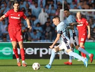 El delantero del Celta Iago Aspas golpea un balón ante el delantero croata del Friburgo Igor Matanovic durante el partido de vuelta de cuartos de final de la Liga Europa, este jueves en el estadio de Balaídos.
