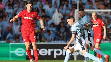 El delantero del Celta Iago Aspas golpea un balón ante el delantero croata del Friburgo Igor Matanovic durante el partido de vuelta de cuartos de final de la Liga Europa, este jueves en el estadio de Balaídos.